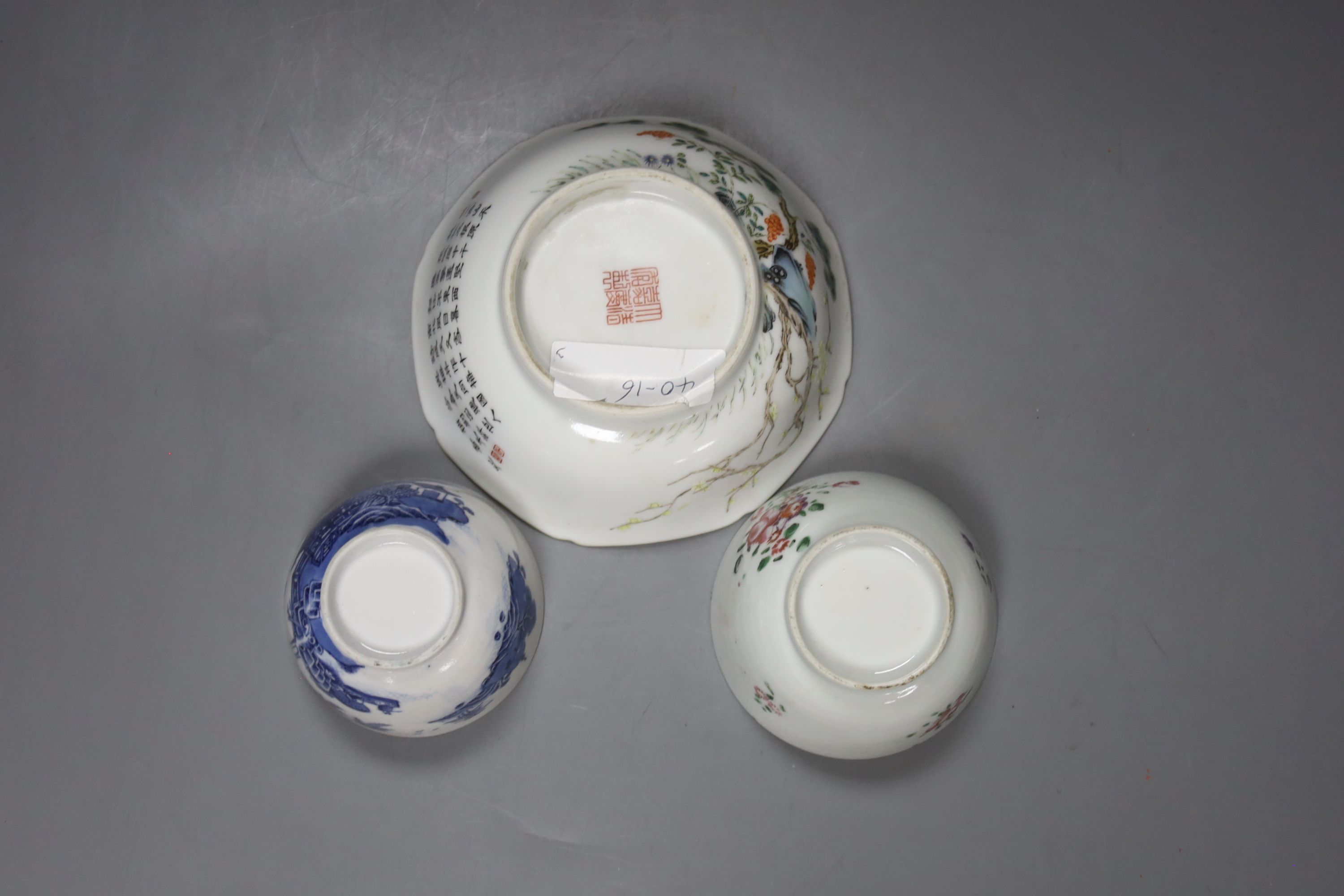 Two Chinese famille rose bowls together with a similar blue and white bowl, largest diameter 14cm